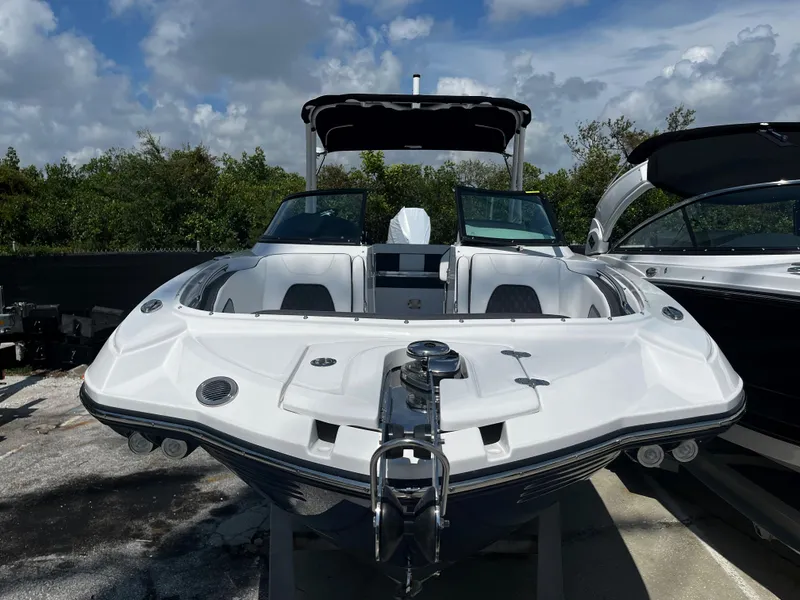 Slide: The Image of 2024 Monterey M-65 boat with sleek design, docked under a partly cloudy sky. - 2