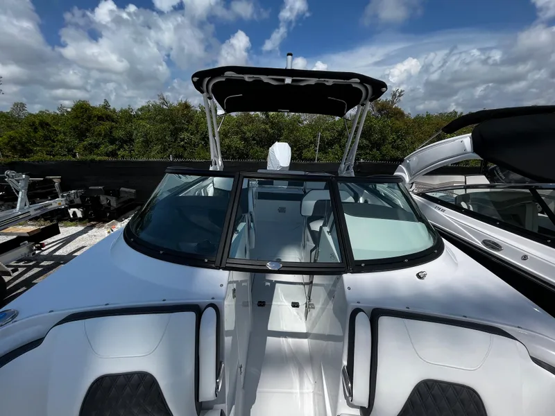 Slide: The Image of 2024 Monterey M-65 boat with black canopy and sleek white interior. - 23