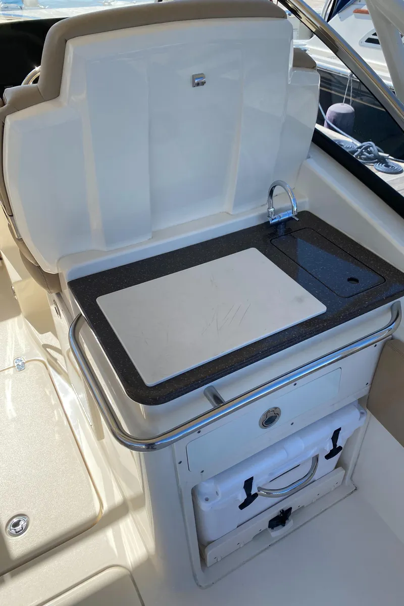 Slide: The Image of 2022 Scout 255 Dorado boat interior with cutting board and storage compartment. - 11