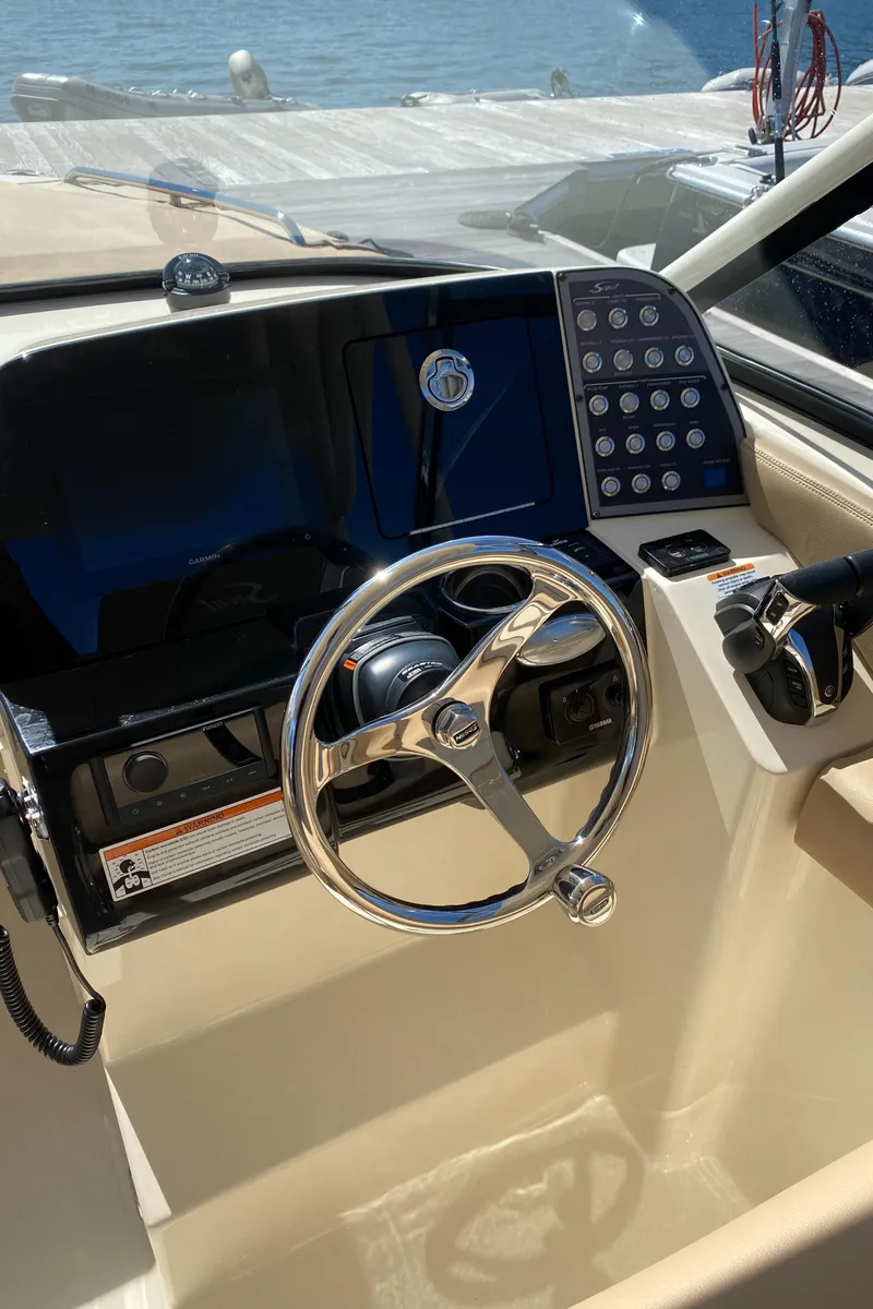 Slide: The Image of 2022 Scout 255 Dorado boat dashboard with steering wheel and control panel. - 13