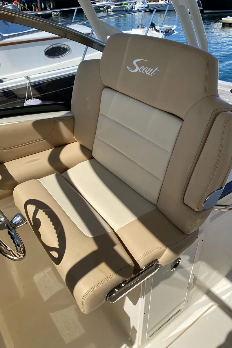 Slide: The Image of 2022 Scout 255 Dorado boat captain's seat with beige and white upholstery. - 15