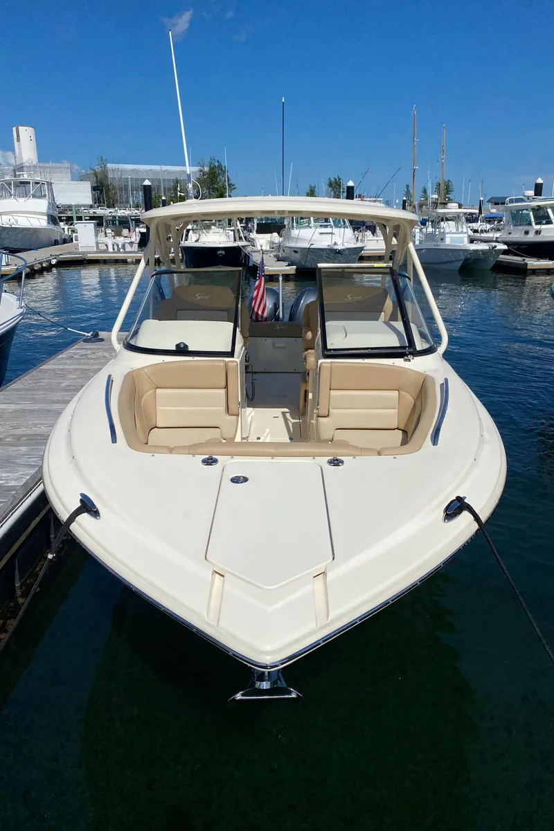 Slide: The Image of 2022 Scout 255 Dorado boat docked at a marina on a sunny day. - 2