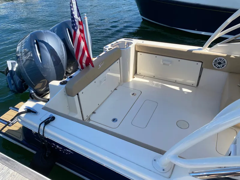 Slide: The Image of 2022 Scout 255 Dorado boat with twin engines and American flag at dock. - 5