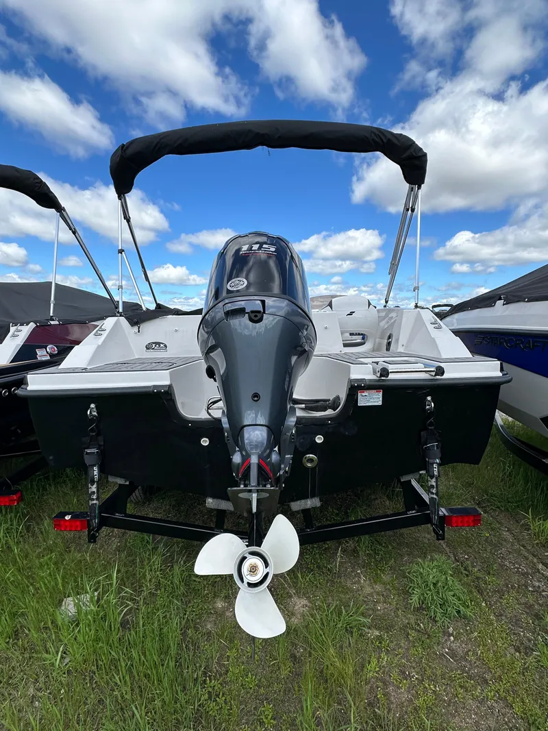 Slide: The Image of 2024 Starcraft SVX171 boat with outboard motor, rear view, parked on grass. - 10