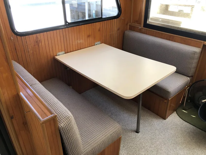 Slide: The Image of Cozy dining area in a 1993 Gibson 37 Sport Series boat with wooden paneling. - 14