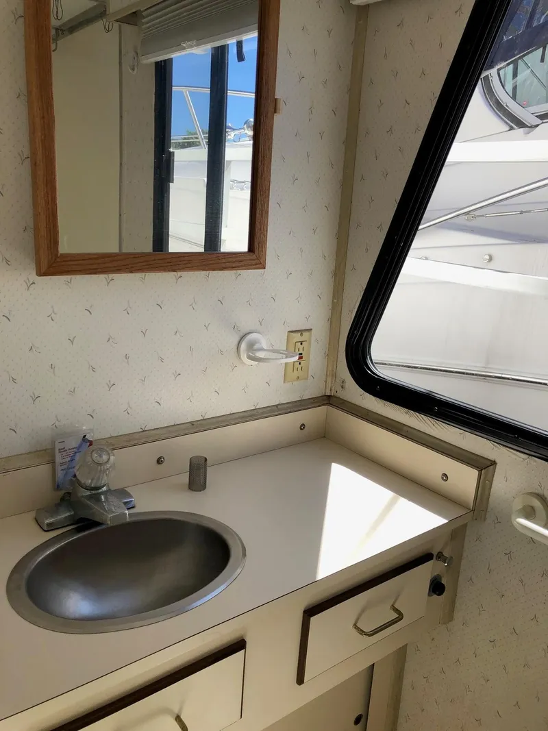 Slide: The Image of 1993 Gibson 37 Sport Series boat bathroom with sink, mirror, and window. - 16