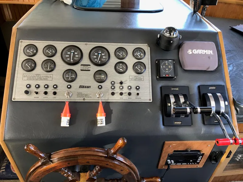 Slide: The Image of 1993 Gibson 37 Sport Series boat control panel with gauges, Garmin GPS, and wooden steering wheel. - 8