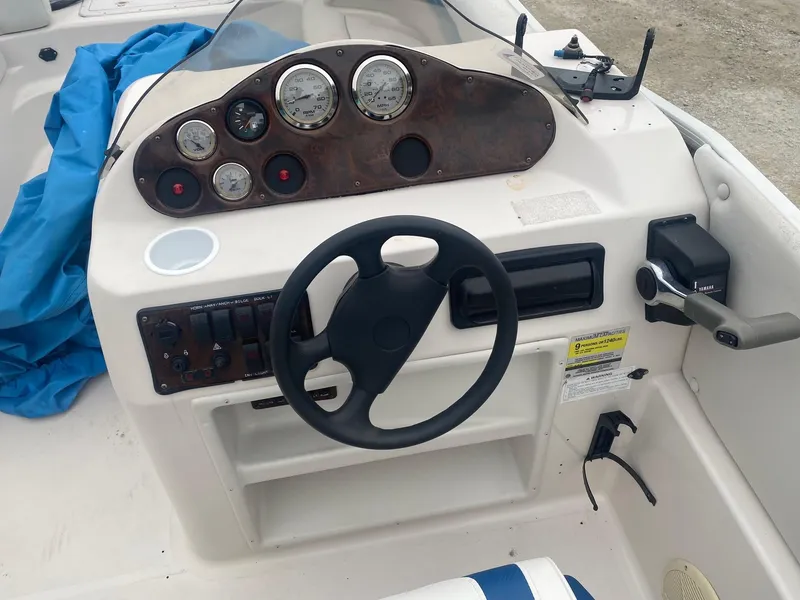 Slide: The Image of 2001 Hurricane 198R boat dashboard with steering wheel, gauges, and controls. - 6