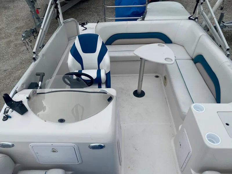 Slide: The Image of 2001 Hurricane 198R boat interior with white and blue seating, steering console, and small table. - 9