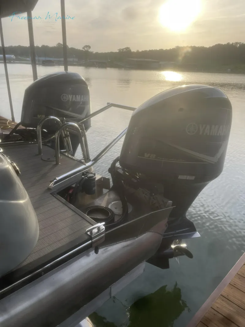 Slide: The Image of 2021 Manitou 27 LX SRW Duel Engine boat with Yamaha motors docked at sunset. - 3