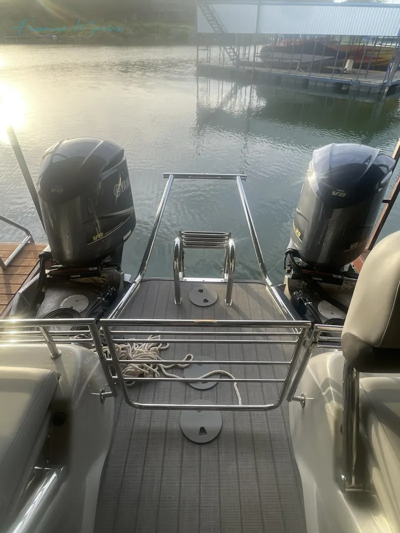 Slide: The Image of 2021 Manitou 27 LX SRW Duel Engine boat docked by the water. - 9