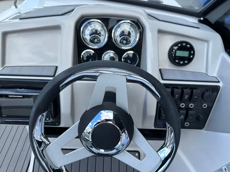 Slide: The Image of 2024 Starcraft SVX 230 OB boat dashboard with steering wheel and control panel. - 15