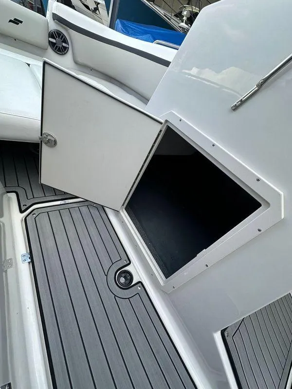Slide: The Image of 2024 Starcraft SVX 230 OB boat interior with gray flooring and white seating. - 23