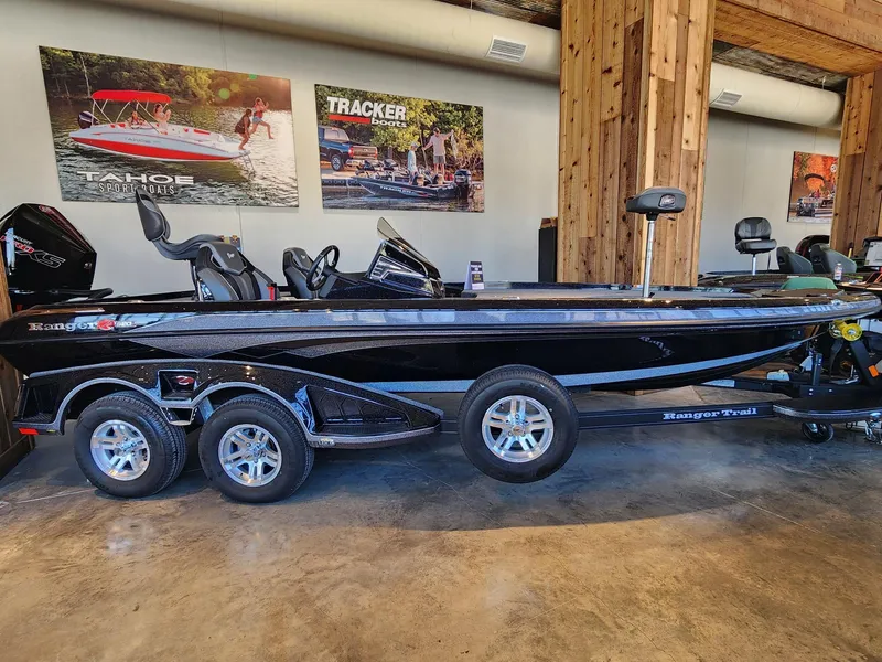 Slide: The Image of 2024 Ranger Z520R bass boat in a workshop, showcasing sleek design and dual-axle trailer. - 0