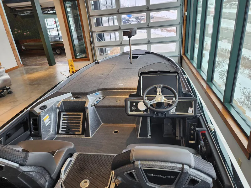 Slide: The Image of 2024 Ranger Z521R boat interior with steering wheel and seating in showroom. - 2