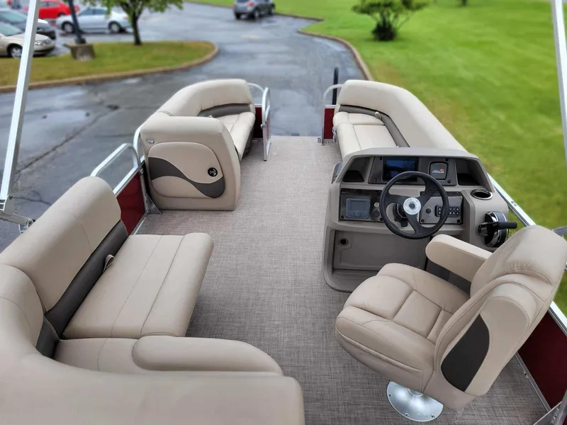 Slide: The Image of 2024 Sun Tracker Party Barge 18 DLX interior with beige seating and steering console. - 5