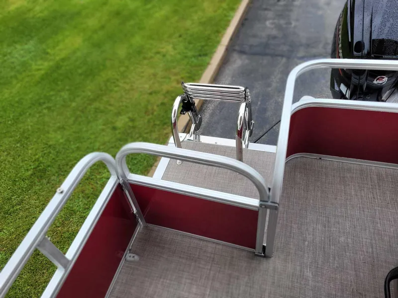 Slide: The Image of 2024 Sun Tracker Party Barge 18 DLX pontoon boat, rear deck view with ladder and railing. - 6