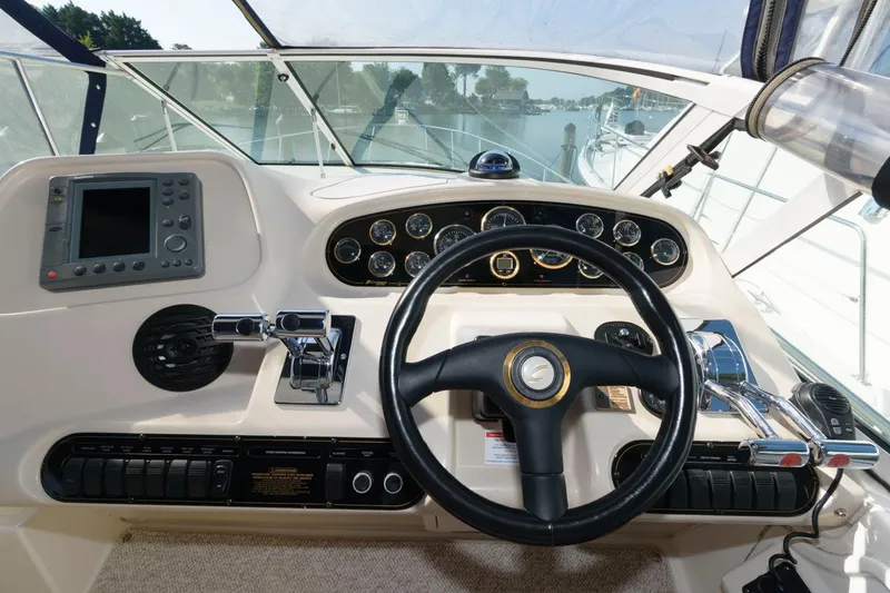 Slide: The Image of 2000 Cruisers Yachts 3672 Express helm with steering wheel and navigation controls. - 10