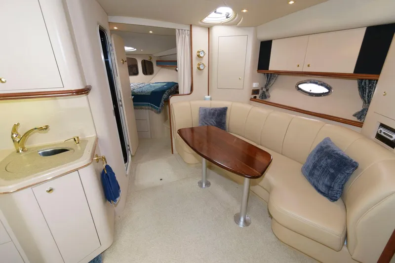 Slide: The Image of Interior of 2000 Cruisers Yachts 3672 Express with beige seating and wooden table. - 13