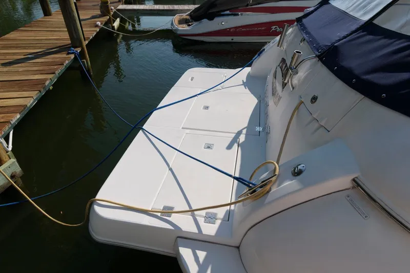 Slide: The Image of 2000 Cruisers Yachts 3672 Express docked, showing swim platform and mooring lines. - 4