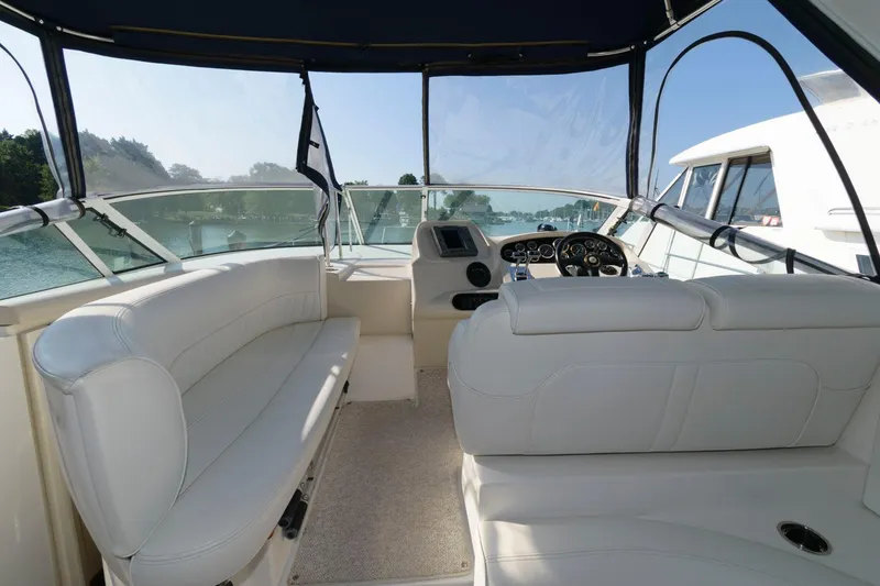 Slide: The Image of Interior view of 2000 Cruisers Yachts 3672 Express with white seating and helm. - 7