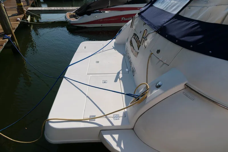 Slide: The Image of 2000 Cruisers Yachts 3672 Express docked, showing stern and swim platform. - 3