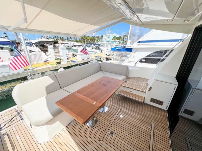 Slide: The Image of Prestige 520 S 2020 yacht with spacious outdoor seating and wooden table at marina. - 5