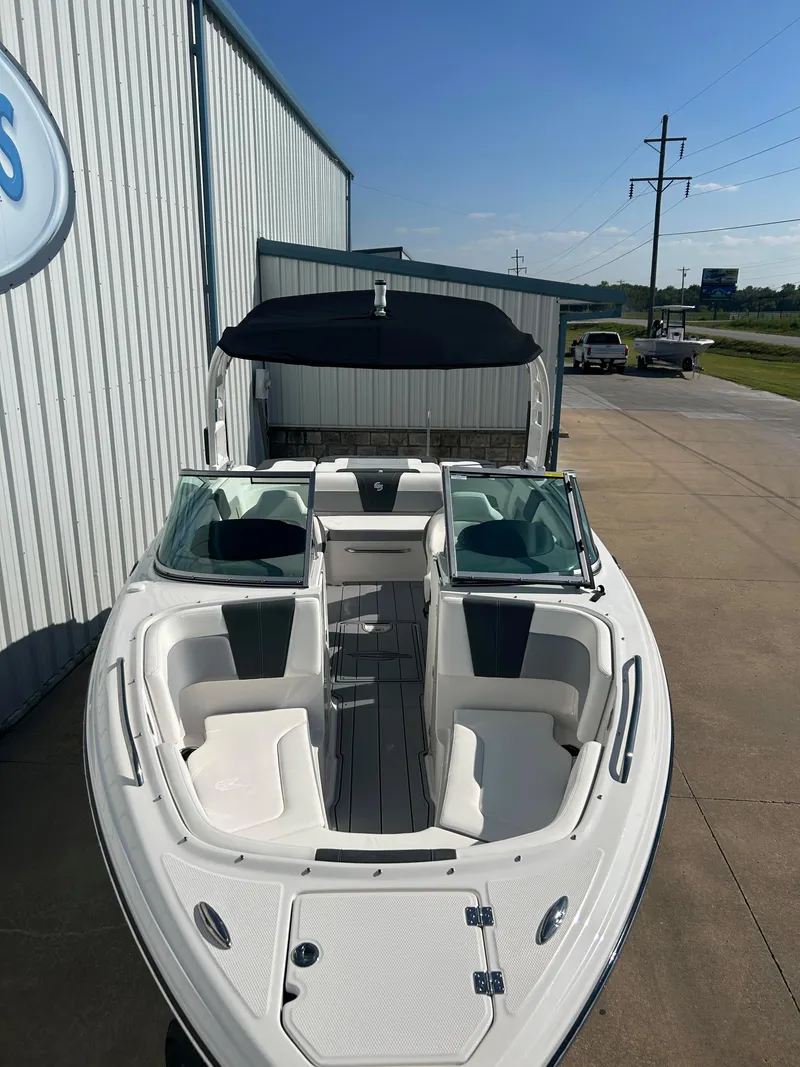 Slide: The Image of 2024 Chaparral 23 Surf boat with white interior, docked outside. - 8