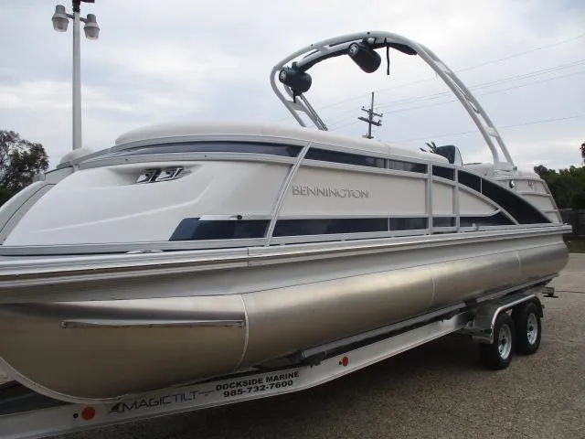 Slide: The Image of 2023 Bennington 25QFBA pontoon boat on a trailer at a marina. - 5