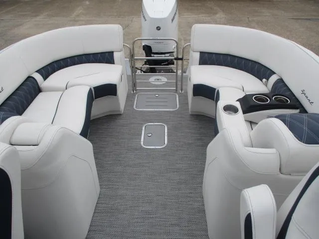Slide: The Image of 2023 Bennington 25QFBA boat interior with white and navy seating, cup holders, and a spacious layout. - 9