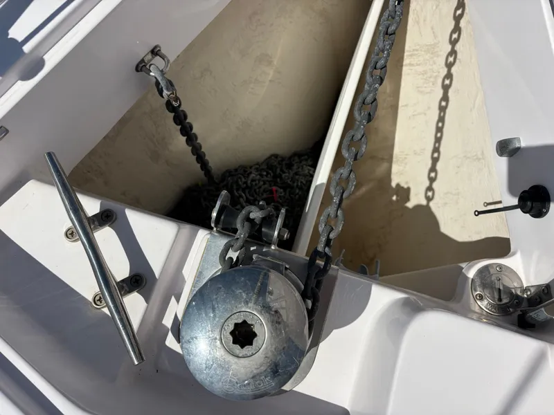 Slide: The Image of Anchor chain compartment on a 2019 Catalina 385 sailboat, featuring metal chains and winch. - 16