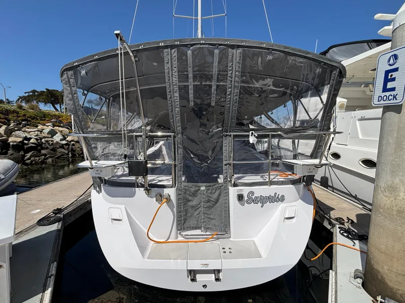 Slide: The Image of 2019 Catalina 385 sailboat docked, featuring a covered cockpit and visible marina surroundings. - 17