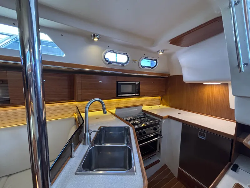 Slide: The Image of Modern kitchen interior of 2019 Catalina 385 yacht with dual sinks and stainless steel appliances. - 25