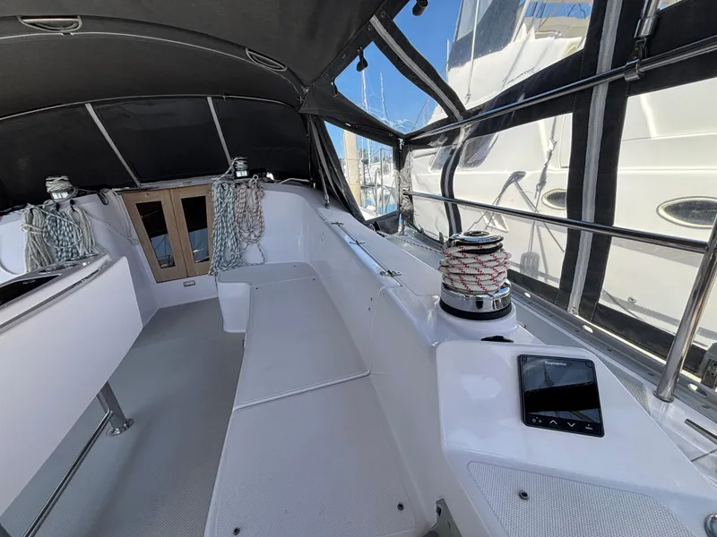 Slide: The Image of 2019 Catalina 385 sailboat cockpit with winch, ropes, and seating under a canopy. - 3