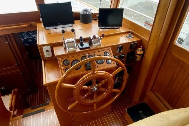 Slide: The Image of Helm of 2002 Grand Banks 46 Classic yacht with wooden steering wheel and navigation equipment. - 10