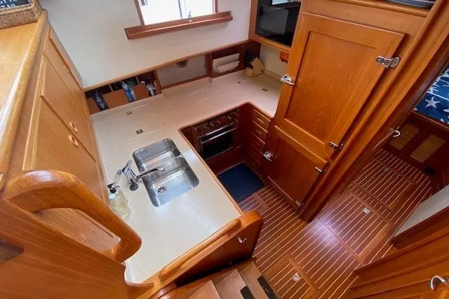 Slide: The Image of Luxurious 2002 Grand Banks 46 Classic yacht interior with wooden cabinetry and modern kitchen amenities. - 17