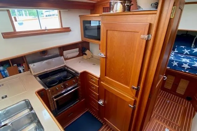 Slide: The Image of 2002 Grand Banks 46 Classic yacht kitchen with wood cabinetry and modern appliances. - 19