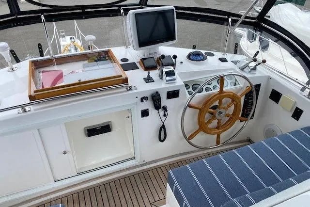 Slide: The Image of Helm of 2002 Grand Banks 46 Classic yacht with wooden wheel and navigation equipment. - 2