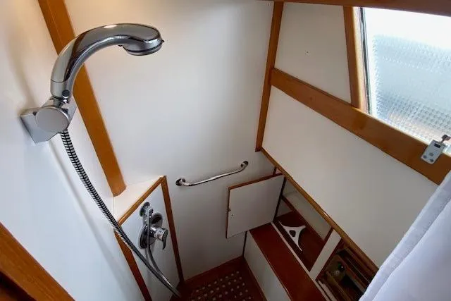 Slide: The Image of Shower area in 2002 Grand Banks 46 Classic yacht with wooden accents and handheld showerhead. - 31
