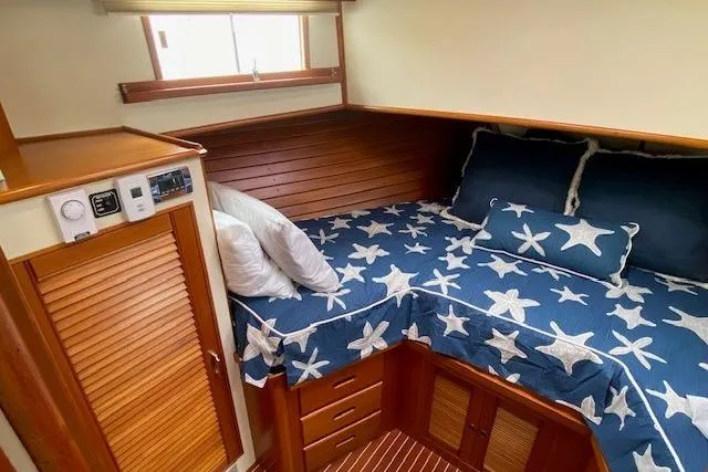 Slide: The Image of Cozy cabin interior of 2002 Grand Banks 46 Classic with star-patterned bedding. - 32