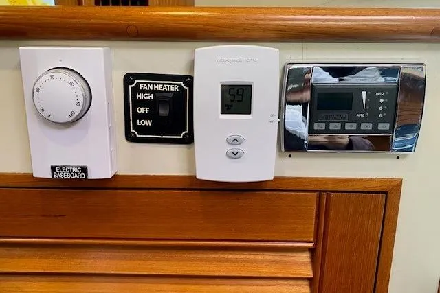 Slide: The Image of Control panel on a 2002 Grand Banks 46 Classic yacht, featuring thermostat and fan heater settings. - 35