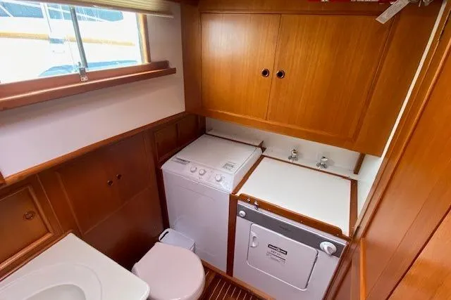 Slide: The Image of Laundry area on 2002 Grand Banks 46 Classic yacht with washer, dryer, and wooden cabinetry. - 37