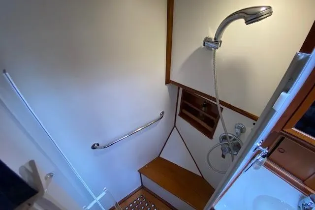 Slide: The Image of Shower area in 2002 Grand Banks 46 Classic yacht with wooden accents and handheld showerhead. - 39