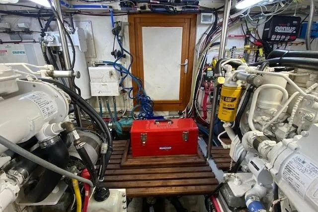 Slide: The Image of Engine room of 2002 Grand Banks 46 Classic with red toolbox and mechanical equipment. - 42