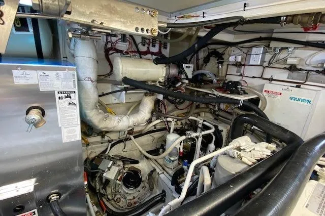 Slide: The Image of Engine room of a 2002 Grand Banks 46 Classic yacht, showcasing mechanical components. - 48