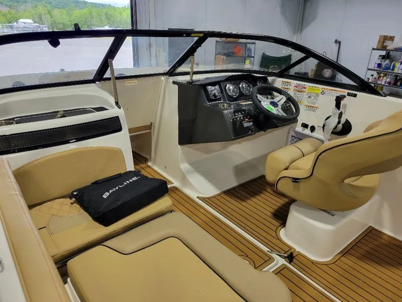 Slide: The Image of 2024 Bayliner VR5 boat interior with tan seating and modern dashboard. - 10