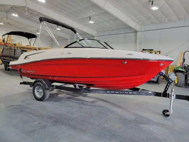 Slide: The Image of 2024 Bayliner VR5 boat with red hull on trailer in indoor showroom. - 3