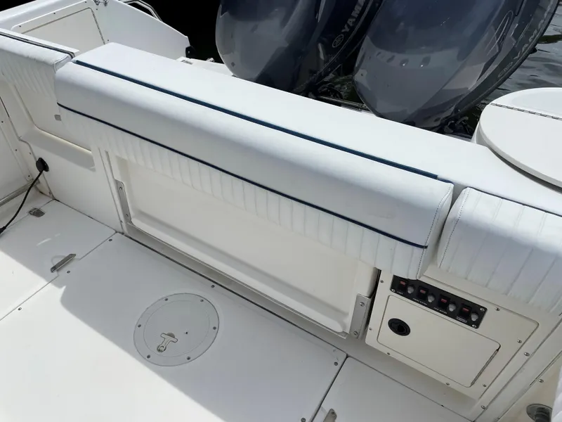Slide: The Image of 1999 Boston Whaler Outrage 23 boat interior with cushioned seating and dual outboard motors. - 6