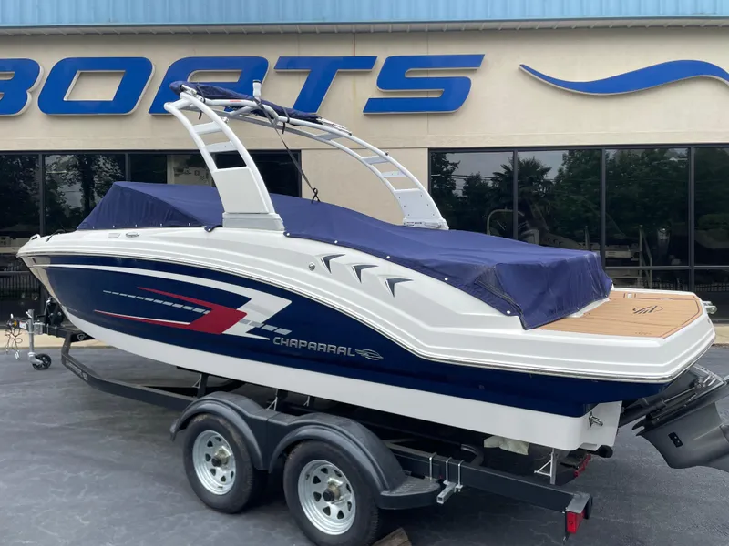 Slide: The Image of 2025 Chaparral 23 SSi boat on trailer in showroom with banners. - 2