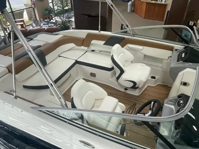 Slide: The Image of 2024 Chaparral 23 SSi boat interior with white and tan seating, modern design. - 9